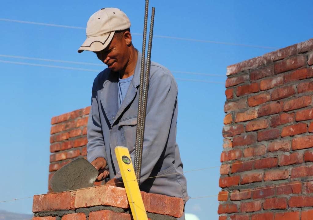 Albañil levantando un muro de ladrillo
